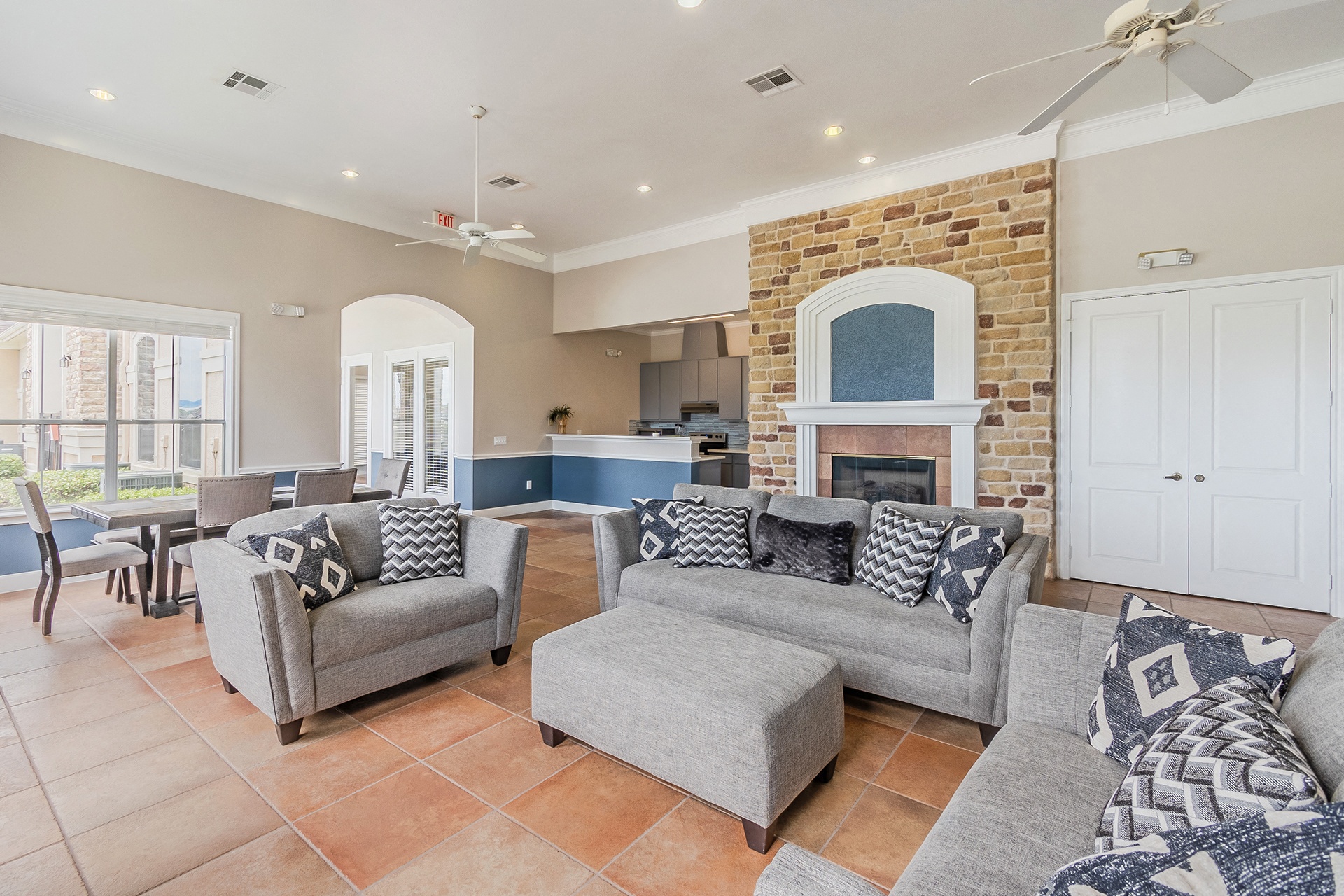 a living room with couches and chairs and a brick fireplace